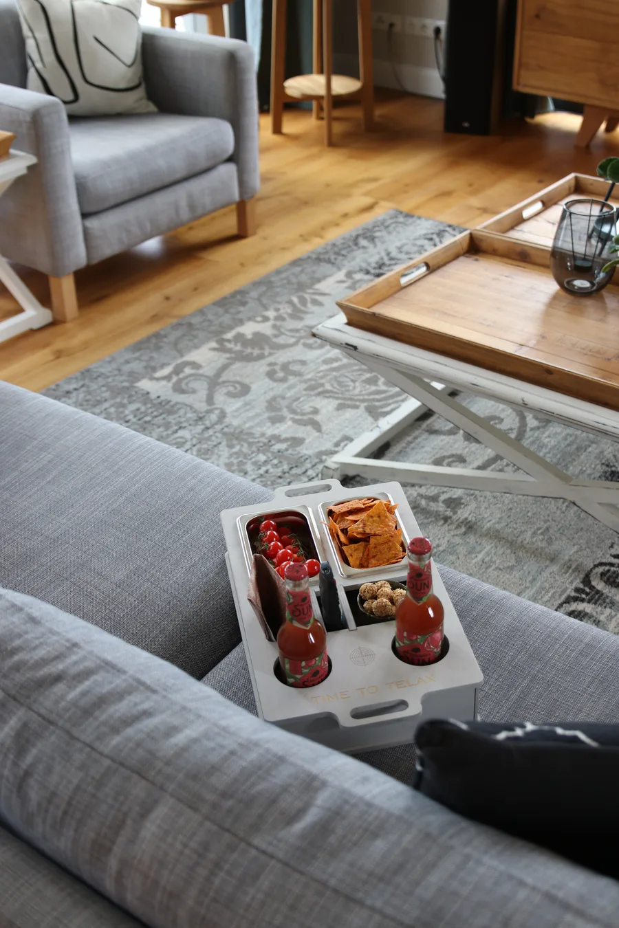 Handyfoto einer Couchbar mit Snacks auf einem grauen Sofa