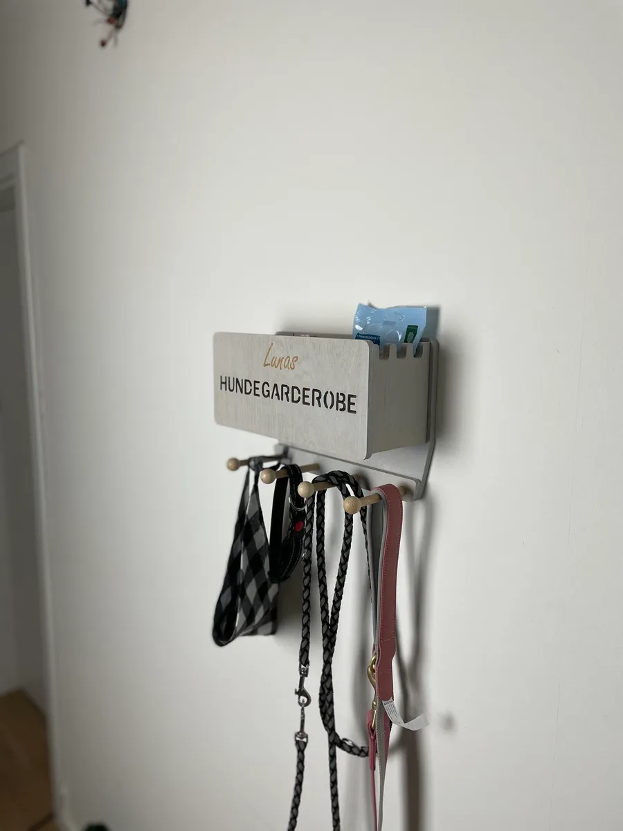 Handyfoto einer Hundegarderobe mit Leinen an einer weißen Wand